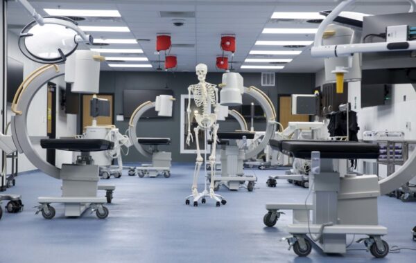 a model skeleton among the operating tables in the bioskills lab